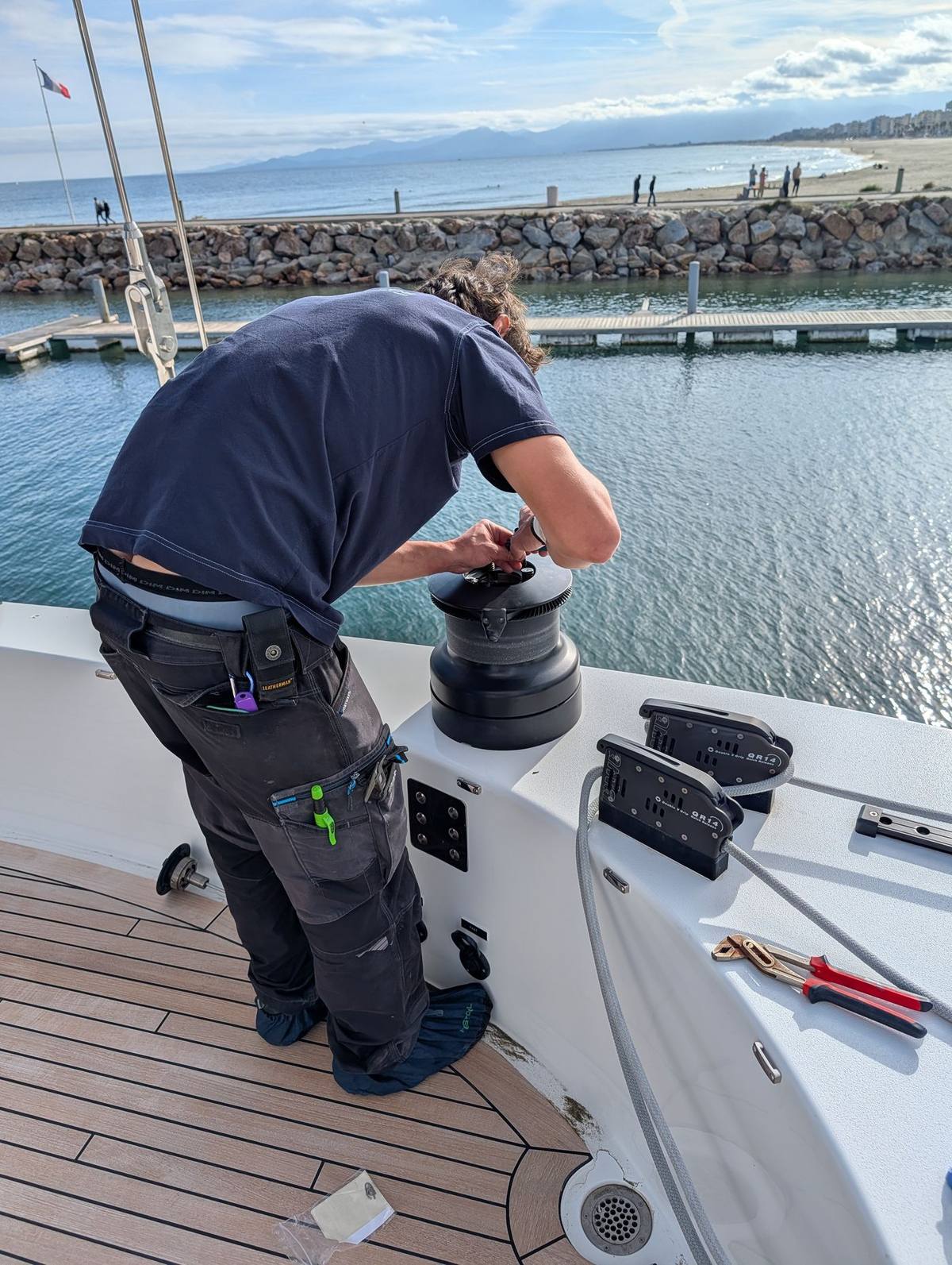 Révision d'un winch sur le pont d'un bateau, port de Canet-en-Roussillon
