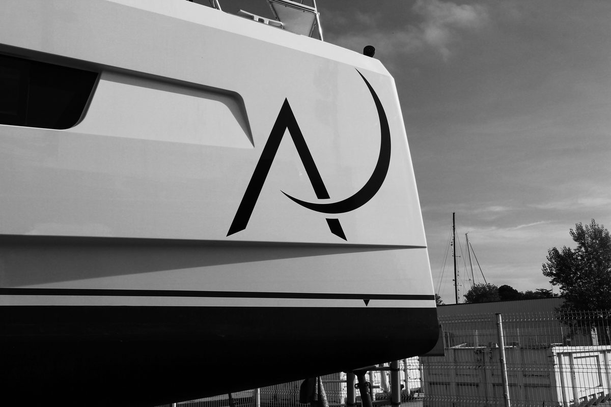 Monogramme AJ personnalisé posé sur la coque d'un catamaran — identité visuelle par Nexus Marine