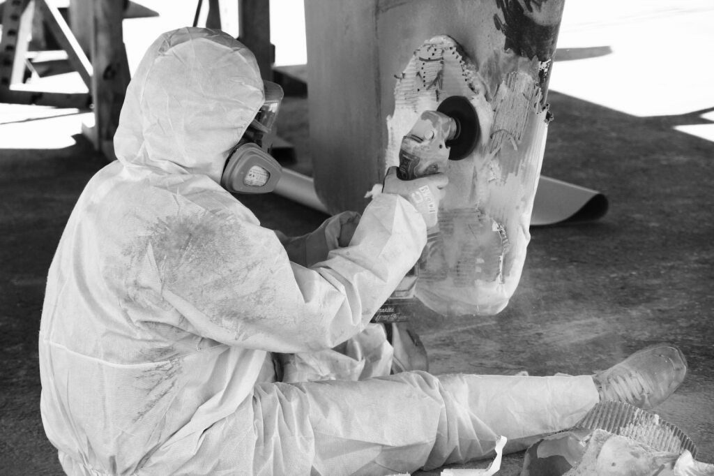 Technicien Nexus Marine travaillant sur la coque d'un catamaran en réparation composite